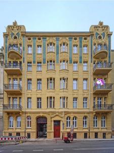 a yellow building with balconies on a street at Loft z Antresolą i Balkonem w Centrum Łodzi Przystań Jednorożca Klimatyzacja Faktura in Łódź