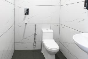 可瓦兰Hotel Samudra Tara的带马桶和水槽的白色浴室
