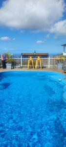 a blue swimming pool with a playground in the background at Au doux Tamarin des hauts in Le Tampon