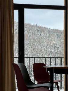 una mesa y sillas frente a una ventana en Chalet Panorama (Апартаменти), en Bukovel