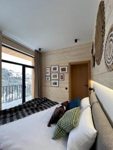 Un dormitorio con una cama grande y una ventana grande en Chalet Panorama (Апартаменти), en Bukovel