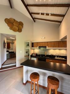 a kitchen with a counter and two stools at KORA MAR - Taipu de Fora - BA in Barra Grande