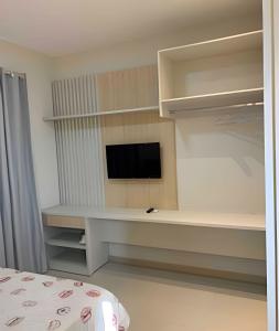 a living room with a tv and a bed at Apartamentos novos em condomínio no Caçari in Boa Vista