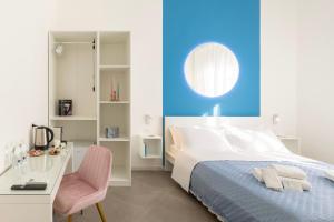 a bedroom with a bed and a desk and a chair at Maddalena Rooms - Eja Sardinia in Cagliari
