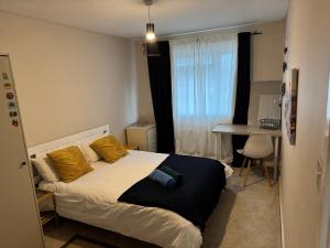 a bedroom with a bed with yellow pillows and a desk at Sunflower villa in Brislington