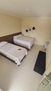 a hotel room with two beds and a mirror at Casa de temporada em Prado-BA in Prado +8 photos