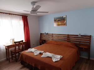 a bedroom with a bed with two towels on it at Posada Karut Josh in El Calafate