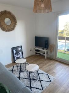a living room with a couch and two tables and a tv at Ramonville parking Privé balcon café in Ramonville-Saint-Agne
