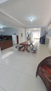 a large living room with a wooden table and bench at Casa de temporada em Prado-BA in Prado