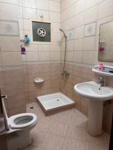 een badkamer met een toilet, een wastafel en een douche bij Stunning Corniche view in Ras al Khaimah +4 foto's