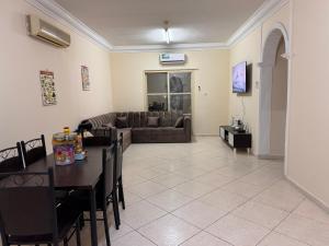 een woonkamer met een tafel en een bank bij Stunning Corniche view in Ras al Khaimah