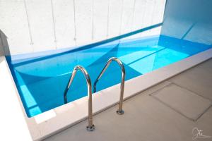 a swimming pool with blue tile and two handles at Villa Marisari in Otok Lastovo