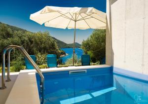 a pool with an umbrella and a view of the water at Villa Marisari in Otok Lastovo +57 photos