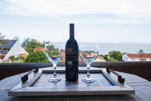 a bottle of wine sitting on a tray with two glasses at Eden Rose Manor B&B in La Mercy