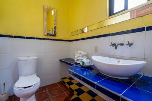 a bathroom with a white toilet and a sink at Hotel Villa Mozart y Macondo in Puerto Escondido