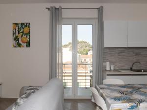 a bedroom with a bed and a kitchen with a balcony at Vista Capo d'Orlando in Capo dʼOrlando