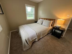 a bedroom with a bed and a window and a lamp at Cute & Cozy 2 Bedroom Near Park in Midland