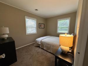 a bedroom with a bed and two windows at Cute & Cozy 2 Bedroom Near Park in Midland