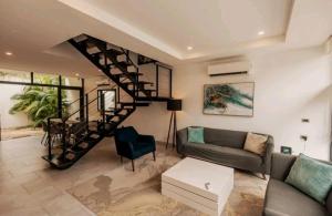 a living room with a couch and a spiral staircase at Villa Roma in Akumal