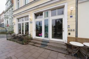 Maisonette am Holstentor mit Dachterrasse und Heimkino في لوبيك: مطعم بطاولات وكراسي خارج المبنى