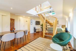 Maisonette am Holstentor mit Dachterrasse und Heimkino في لوبيك: غرفة معيشة مع درج وطاولة وكراسي