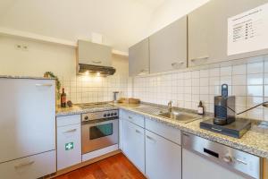 Maisonette am Holstentor mit Dachterrasse und Heimkino في لوبيك: مطبخ بخزائن بيضاء ومغسلة +7 صور