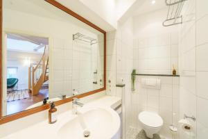 Maisonette am Holstentor mit Dachterrasse und Heimkino في لوبيك: حمام مع حوض ومرحاض ومرآة