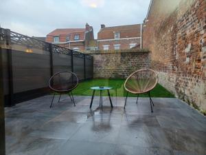 two chairs and a table on a patio at Appartement jardin bailleul 02 in Bailleul