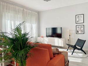 sala de estar con sofá naranja y TV en Serena Arte, en Zaragoza