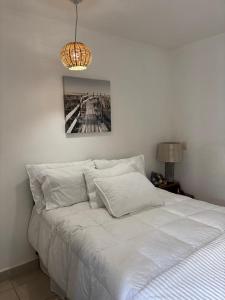 a bedroom with a white bed and a chandelier at Casa matamoros in Oaxaca City