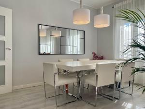 Un comedor blanco con una mesa y sillas blancas. en Serena Arte, en Zaragoza