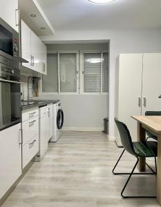Una cocina con gabinetes blancos y una mesa y una silla. en Serena Arte, en Zaragoza 9 fotos más