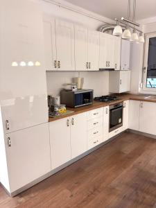 a kitchen with white cabinets and a microwave at Mirvana Apartments Solis Grande in Timişoara