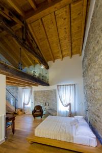 a bedroom with a bed and a stone wall at Relais Il Presidio in Oggiono
