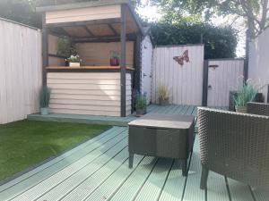 a wooden deck with a picnic table and a shed at Pebble Cottage in Hunstanton