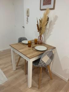 einen Holztisch mit zwei Tellern und zwei Stühlen in der Unterkunft Appartement Cozy in Avesnes-sur-Helpe