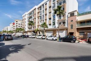 Una calle de la ciudad con coches aparcados delante de un edificio. en Casa Lilas Free Parking & Gym & Optical Fiber Oldtown 5 mn Walk, en Rabat
