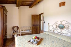 a bedroom with a bed with a tray of fruit on it at PanElios Borgo Vacanze in Città della Pieve
