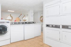 a kitchen with white cabinets and a washer and dryer at Modern Comfort Easy Access to Bay Area Attractions in Houston