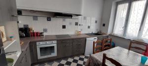 a kitchen with a stove and a sink and a table at Maison Cosy à Rieux-Minervois in Rieux-Minervois