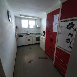 una cocina con puerta roja y refrigerador rojo y blanco en Bunderbach, en Adelboden