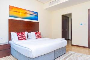 Aspire Tower - Spacious One Bedroom Apartment في المنامة: غرفة نوم بها سرير كبير ولوحة فنية على الحائط +25 صورة