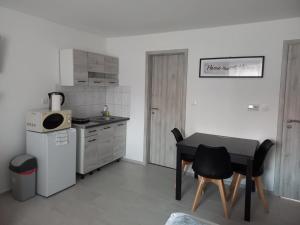 a kitchen with a table and a small table and chairs at BB64 Apartmanház in Békéscsaba