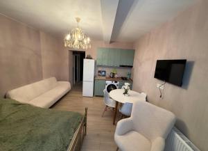 a living room with a couch and a table and a kitchen at თბილისი in Bakuriani