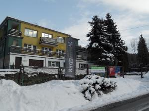 a building with a sign in the snow at Willa Eden in Krynica Zdrój