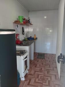 a kitchen with a white stove and a wooden floor at Apartamento e suítes Itacaré in Itacaré