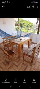 a wooden table and two chairs and a hammock at Apartamento e suítes Itacaré in Itacaré