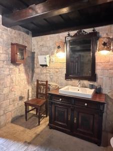 a bathroom with a sink and a chair at Kusper Vendégház 1846 in Bükkzsérc +35 photos