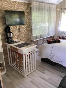 a bedroom with a bed and a desk with a coffee maker at Šturmų Sodyba in Ventė