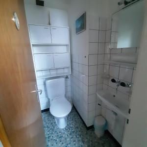 a white bathroom with a toilet and a sink at Bunderbach in Adelboden +12 photos
